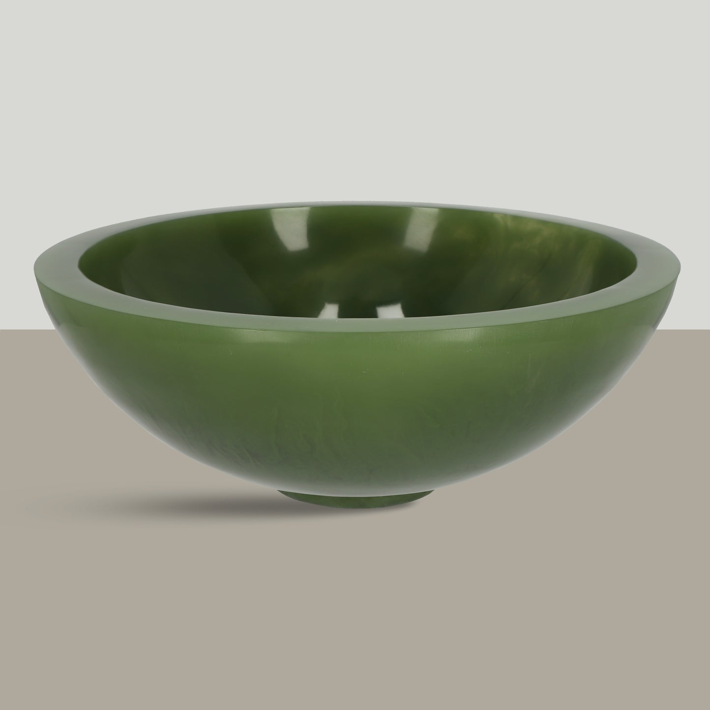 A hand-cast, polished decorative bowl with a unique green gradient, minimalist in design.